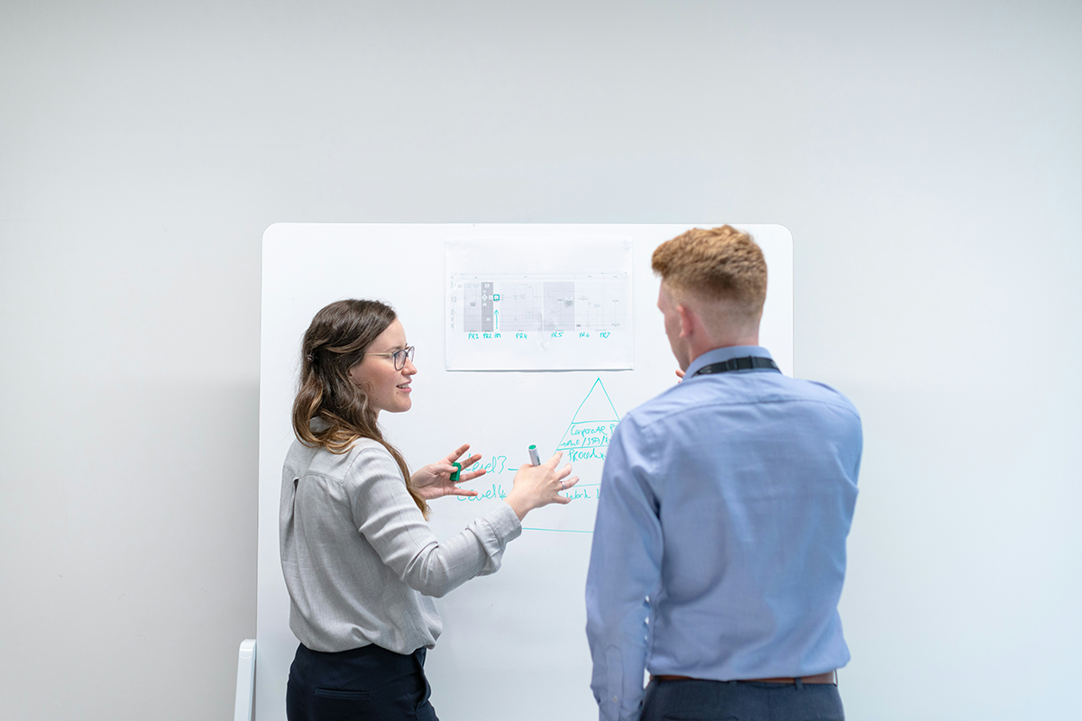 Zwei Personen vor Whiteboard, gemeinsame Abstimmung